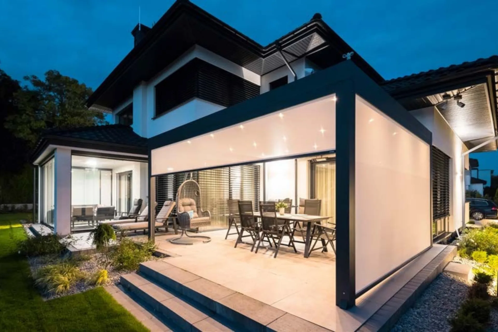 Pergola prie namo su išskleistais šoniniais roletais